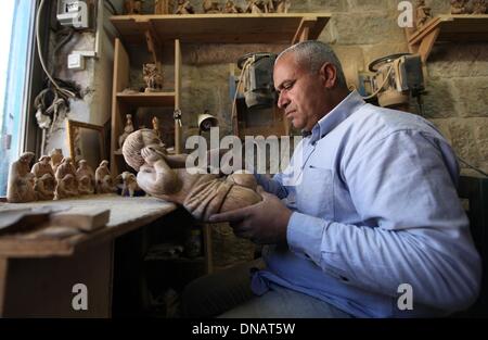 Betlemme. Xxi Dec, 2013. Un falegname palestinese fa una statua in legno prima le imminenti feste di Natale a un workshop in Cisgiordania città di Betlemme il 21 dicembre, 2013. Credito: Luay Sababa/Xinhua/Alamy Live News Foto Stock