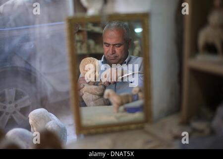 Betlemme. Xxi Dec, 2013. Un falegname palestinese facendo una statua in legno prima le imminenti feste di Natale viene riflessa in uno specchio a un workshop in Cisgiordania città di Betlemme il 21 dicembre, 2013. Credito: Luay Sababa/Xinhua/Alamy Live News Foto Stock