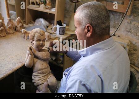 Betlemme. Xxi Dec, 2013. Un falegname palestinese fa una statua in legno prima le imminenti feste di Natale a un workshop in Cisgiordania città di Betlemme il 21 dicembre, 2013. Credito: Luay Sababa/Xinhua/Alamy Live News Foto Stock