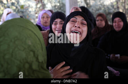 La striscia di Gaza, Territori palestinesi. Xxi Dec, 2013. Un parente di Odah palestinese Hamad piange durante il suo funerale in Beit Hanoun nel nord della Striscia di Gaza il 21 dicembre 2013. Le forze israeliane hanno sparato e ucciso un palestinese, Hamad, 22-anno-vecchio e ferito altri tre in tre separati incidenti transfrontaliera di violenza nella Striscia di Gaza il venerdì, i funzionari palestinesi detto. I militari israeliani che ha a lungo detta zona di Gaza lungo la recinzione di confine è off limits, ha detto che stava cercando nelle relazioni.Foto: Majdi Fathi/NurPhoto Credito: Majdi Fathi/NurPhoto/ZUMAPRESS.com/Alamy Live News Foto Stock