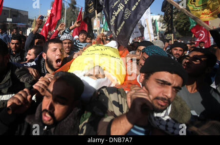 La striscia di Gaza, Territori palestinesi. Xxi Dec, 2013. Persone in lutto portano il corpo di 22-anno-vecchio Odah palestinese Hamad durante il suo funerale in Beit Hanoun nel nord della Striscia di Gaza il 21 dicembre 2013. Le forze israeliane hanno sparato e ucciso un palestinese, Hamad, e ferito altri tre in tre separati incidenti transfrontaliera di violenza nella Striscia di Gaza il venerdì, i funzionari palestinesi detto. I militari israeliani che ha a lungo detta zona di Gaza lungo la recinzione di confine è off limits, ha detto che stava cercando nelle relazioni.Foto: Majdi Fathi/NurPhoto Credito: Majdi Fathi/NurPhoto/ZUMAPRESS.com/Alamy Live News Foto Stock