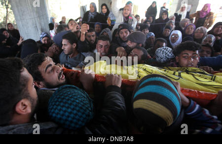 La striscia di Gaza, Territori palestinesi. Xxi Dec, 2013. Persone in lutto portano il corpo di 22-anno-vecchio Odah palestinese Hamad durante il suo funerale in Beit Hanoun nel nord della Striscia di Gaza il 21 dicembre 2013. Le forze israeliane hanno sparato e ucciso un palestinese, Hamad, e ferito altri tre in tre separati incidenti transfrontaliera di violenza nella Striscia di Gaza il venerdì, i funzionari palestinesi detto. I militari israeliani che ha a lungo detta zona di Gaza lungo la recinzione di confine è off limits, ha detto che stava cercando nelle relazioni.Foto: Majdi Fathi/NurPhoto Credito: Majdi Fathi/NurPhoto/ZUMAPRESS.com/Alamy Live News Foto Stock