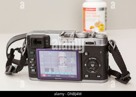 Fujifilm X100 retrò fotocamera digitale compatta con display LCD posteriore che mostra le impostazioni e modalità live view fotografando un oggetto Foto Stock