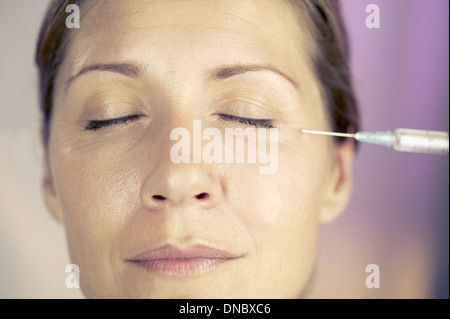 Una donna di mezza età avente una iniezione di Botox Foto Stock