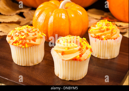 Tortini di colore arancione con zucche e foglie colorate Foto Stock