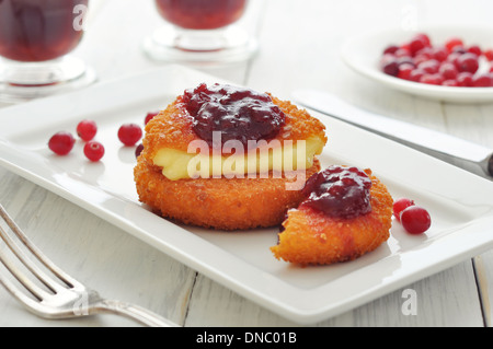 Impanati e camembert al forno con salsa di mirtilli sulla piastra bianca closeup Foto Stock
