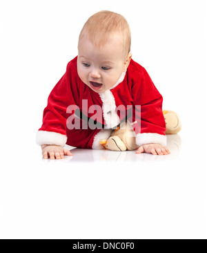 Carino piccolo ragazzo in Santa costume guardando giù su sfondo bianco Foto Stock