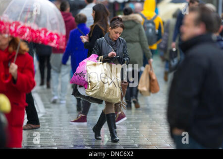 Cardiff, Galles, UK. 22 Dic, 2013. Christmas Shopper shopping per last minute presenta sotto la pioggia il 22 Dic, 2013 a Cardiff, nel Galles, UK. Gli acquirenti sono tenuti a trascorrere £12 miliardi di euro in quattro giorni. Foto: Matteo Horwood/Alamy Live News Foto Stock