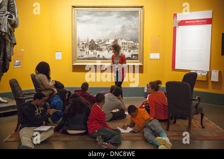 Gli studenti delle scuole superiori imparano a conoscere l'arte in un viaggio al Brooklyn Museum, Brooklyn, New York. 'Winter Scene in Brooklyn', 1820, di Francis Guy sullo sfondo. Foto Stock