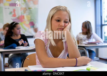 Triste ragazza seduta in aula Foto Stock