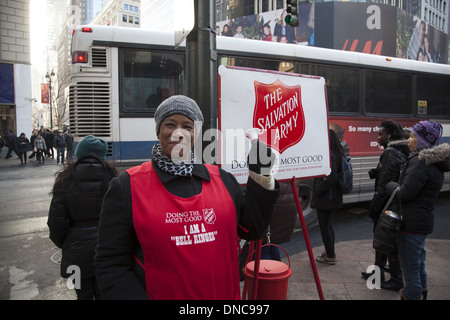 Donna di volontariato raccoglie fondi per l'Esercito della Salvezza durante la stagione di Natale a 34th Street e Broadway, New York. Foto Stock