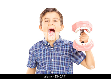Entusiasta il capretto con bocca aperta tenendo un denti campione fatto fuori del calco in gesso Foto Stock