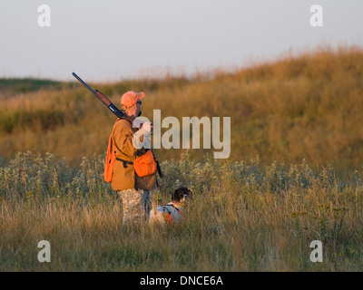 Cacciatore con il suo cane su un inizio di mattina su Prairie del North Dakota Foto Stock