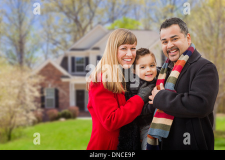 Felice razza mista famiglia giovane nella parte anteriore della bella casa. Foto Stock