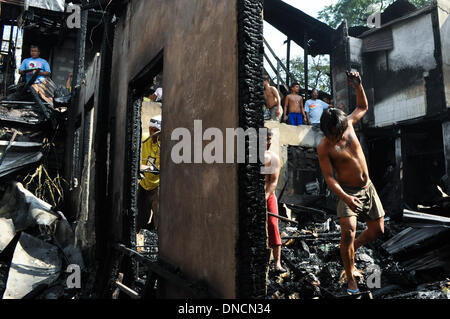Manila, Filippine. 23 Dic, 2013. I volontari di recupero che cosa è rimasto di proprietà di bruciato. Due giorni prima di Natale, un incendio ha colpito una zona residenziale in Barangay aggiunta Hills, suburbana Mandaluyong City, a est di Manila il 23 dicembre 2013. Le relazioni dicono che il fuoco ha iniziato la mattina presto e è stato messo sotto controllo dopo le 9 di mattina.Foto: George Calvelo/NurPhoto Credito: George Calvelo/NurPhoto/ZUMAPRESS.com/Alamy Live News Foto Stock