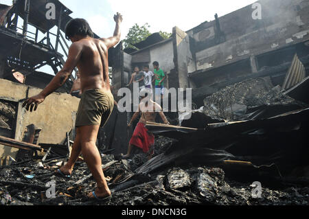 Manila, Filippine. 23 Dic, 2013. I volontari di recupero che cosa è rimasto di proprietà di bruciato. Due giorni prima di Natale, un incendio ha colpito una zona residenziale in Barangay aggiunta Hills, suburbana Mandaluyong City, a est di Manila il 23 dicembre 2013. Le relazioni dicono che il fuoco ha iniziato la mattina presto e è stato messo sotto controllo dopo le 9 di mattina.Foto: George Calvelo/NurPhoto Credito: George Calvelo/NurPhoto/ZUMAPRESS.com/Alamy Live News Foto Stock