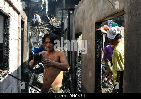Manila, Filippine. 23 Dic, 2013. I volontari di recupero che cosa è rimasto di proprietà di bruciato. Due giorni prima di Natale, un incendio ha colpito una zona residenziale in Barangay aggiunta Hills, suburbana Mandaluyong City, a est di Manila il 23 dicembre 2013. Le relazioni dicono che il fuoco ha iniziato la mattina presto e è stato messo sotto controllo dopo le 9 di mattina.Foto: George Calvelo/NurPhoto Credito: George Calvelo/NurPhoto/ZUMAPRESS.com/Alamy Live News Foto Stock