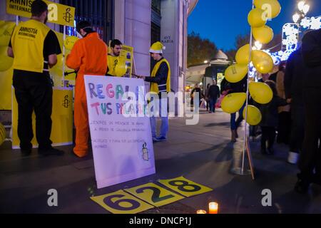 Siviglia, Spagna. 22 Dic, 2013. I membri di Amnesty International partecipare alla campagna di sensibilizzazione ''Regala tus palabras'' (dare via il vostro parole) durante il Natale. Questa campagna intende inviare parole di solidarietà per alcuni prigionieri di coscienza. Quest'anno, i destinatari sono Chen Zhenping, Majid Tavakkoli e Maria Alekhina.Foto: NurPhoto/ZUMAPRESS.com/Alamy Live News Foto Stock