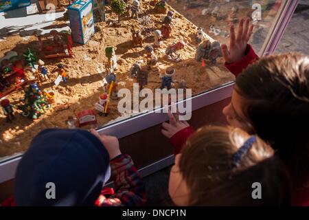 Sevilla, Spagna. 22 Dic, 2013. Alcuni bambini a guardare le cifre per la vendita in un stand commerciali del xx Betlemme portale fiera di Siviglia. Montaggio di un portale di Betlemme in casa è una tradizione popolare durante il periodo di Natale a Siviglia e in altri luoghi di Andalusia.Foto: NurPhoto/ZUMAPRESS.com/Alamy Live News Foto Stock