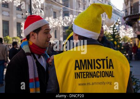 Siviglia, Spagna. 22 Dic, 2013. I membri di Amnesty International partecipare alla campagna di sensibilizzazione ''Regala tus palabras'' (dare via il vostro parole) durante il Natale. Questa campagna intende inviare parole di solidarietà per alcuni prigionieri di coscienza. Quest'anno, i destinatari sono Chen Zhenping, Majid Tavakkoli e Maria Alekhina.Foto: NurPhoto/ZUMAPRESS.com/Alamy Live News Foto Stock