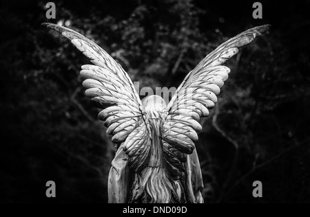 Angelo alato di pietra tombale vista posteriore in bianco e nero Foto Stock