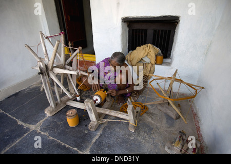 Donna tribale rendendo thread su Charkha, la ruota di filatura, Orissa, India Foto Stock