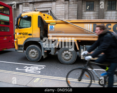 L'uomo ciclista persona escursioni in bicicletta sul marciapiede non in bici nella corsia di traffico pesante vicino a HGV autocarro e red double-decker bus Londra UK KATHY DEWITT Foto Stock