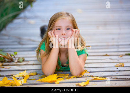 Kid ragazza in autunno ponte di legno con foglie di giallo rilassante ambiente all'aperto Foto Stock