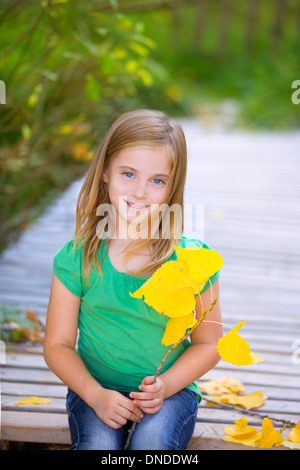 Kid ragazza in autunno ponte di legno con foglie di giallo rilassante ambiente all'aperto Foto Stock