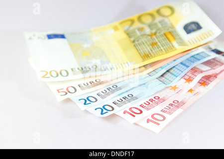 Banconote giacenti su altre note con luce sfondo bianco Foto Stock