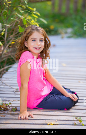 Kid ragazza in autunno ponte sorridente con bretelle denti apparato outdoor Foto Stock