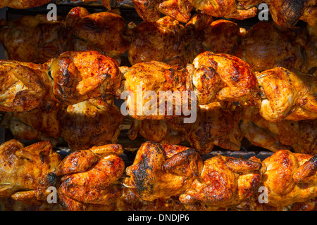 Pollo arrosto in una fila girando alla torrefazione industriale Foto Stock
