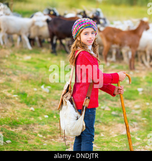 Kid girl pastorella felice con il gregge di pecore e di bastone di legno in Spagna Foto Stock