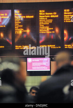 La stazione di Euston, London, Regno Unito. 23 Dic, 2013. Passeggeri attendere come molti treni del Virgin gravemente ritardata a causa di un guasto di alimentazione. I forti venti e tempeste stava causando disagi in tutto il Regno Unito. Credito: Matteo Chattle/Alamy Live News Foto Stock