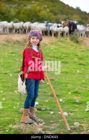 Kid girl pastorella felice con il gregge di pecore e di bastone di legno in Spagna Foto Stock