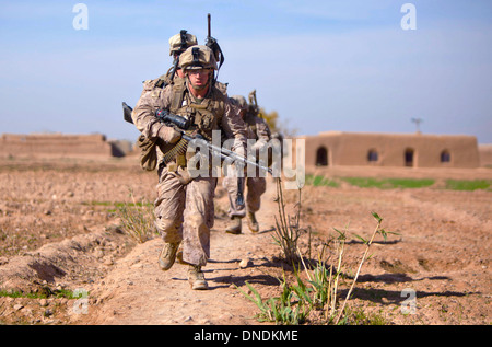 US Marine Corps Lance Cpl. Brian Barker è a capo di un gruppo di Marines per coprire vicino al Bari Gul Bazaar durante un prolungato firefight con i ribelli Dicembre 4, 2013 in NAD Ali distretto, provincia di Helmand, Afghanistan. Foto Stock