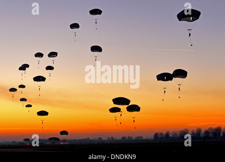 Noi paracadutisti deriva verso il basso durante un tramonto parachute jump Dicembre 11, 2013 in rivolta Air Force Base in Italia. Avieri da Ramstein Air Base, la Germania e la XXXI Fighter Wing presso la base aerea di Aviano, Italia, collabora con soldati dell esercito USA a Vicenza per condurre l'aviosuperficie sequestro le azioni di formazione durante due settimane di aria vicino a sostenere la formazione di esercizio. Foto Stock