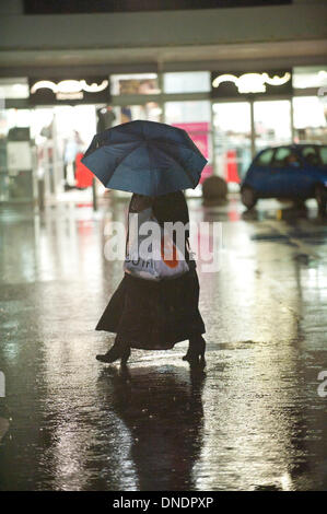 Merthyr Tydfil, Wales, Regno Unito. Il 23 dicembre 2013. Heavy Rain continua senza sosta nel Galles del Sud e last minute gli acquirenti devono negoziare enormi pozzanghere a retail park nella valle città di Merthyr Tydfil. Credito: Graham M. Lawrenc/Alamy Live News. Foto Stock