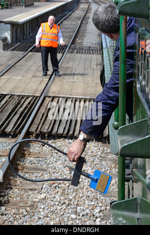 Lo scambio di gettoni è stato consegnato dal conducente del motore al signalman alla fine della singola pista di lavoro sulla ferrovia storica Epping Ongar Foto Stock