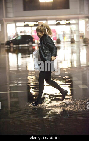 Merthyr Tydfil, Wales, Regno Unito. Il 23 dicembre 2013. Heavy Rain continua senza sosta nel Galles del Sud e last minute gli acquirenti devono negoziare enormi pozzanghere a retail park nella valle città di Merthyr Tydfil. Credito: Graham M. Lawrenc/Alamy Live News. Foto Stock