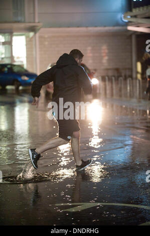 Merthyr Tydfil, Wales, Regno Unito. Il 23 dicembre 2013. Heavy Rain continua senza sosta nel Galles del Sud e last minute gli acquirenti devono negoziare enormi pozzanghere a retail park nella valle città di Merthyr Tydfil. Credito: Graham M. Lawrenc/Alamy Live News. Foto Stock