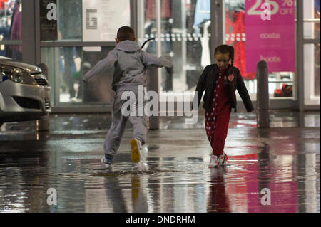 Merthyr Tydfil, Wales, Regno Unito. Il 23 dicembre 2013. Heavy Rain continua senza sosta nel Galles del Sud e last minute gli acquirenti devono negoziare enormi pozzanghere a retail park nella valle città di Merthyr Tydfil. Credito: Graham M. Lawrenc/Alamy Live News. Foto Stock