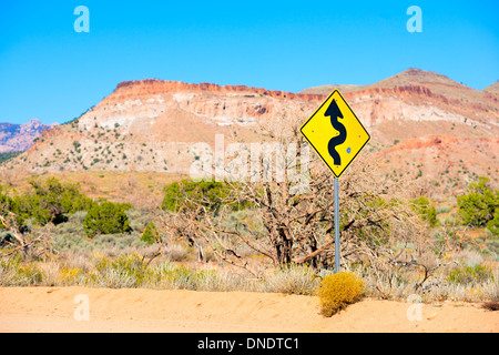 Strada nel deserto con avvolgimento cartello stradale Foto Stock