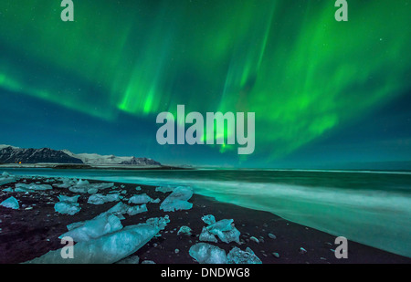 Un bellissimo display aurora oltre la spiaggia di ghiaccio nei pressi di Jokulsarlon, Islanda. Foto Stock