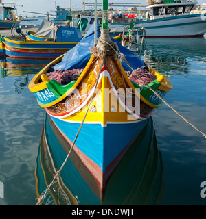 Un colorato luzzu ormeggiata nel porto di Marsaxlokk di Marsaxlokk, Malta. Un luzzu è un maltese tradizionale barca da pesca. Foto Stock