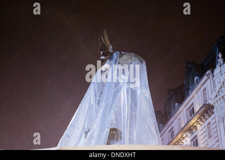 Londra, Regno Unito. 23 Dic, 2013. Giant snow globe intorno a Eros in Piccadilly Circus a Londra si sgonfia a causa del forte vento. Il maltempo ha provocato interruzioni in tutto il Regno Unito. Credito: martyn wheatley/Alamy Live News Foto Stock