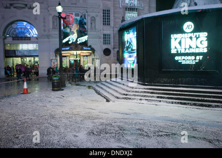 Londra, Regno Unito. 23 Dic, 2013. Giant snow globe intorno a Eros in Piccadilly Circus a Londra si sgonfia a causa del forte vento. Il maltempo ha provocato interruzioni in tutto il Regno Unito. Credito: martyn wheatley/Alamy Live News Foto Stock