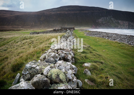 Il vecchio muro di pietra conduce verso Burnmouth Bothy, Rackwick Bay, Hoy, isole Orcadi, Scozia Foto Stock
