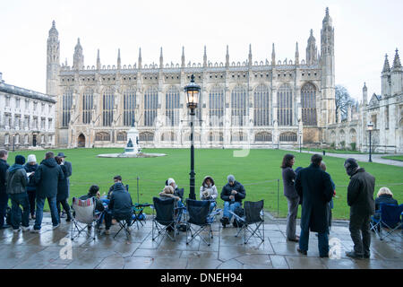 Cambridge, Regno Unito. 24 dicembre, 2013. La gente in coda per il Festival di nove lezioni e canti al King's College di Cambridge Regno Unito, poco dopo l'alba 24 dicembre 2013. Alcuni hanno dormito tutta la notte, sfidando il bagnato e ventoso che ha attraversato il paese per ottenere un buon posto nella coda. Il tradizionale Natale carol concerto ha luogo successivamente alla vigilia di Natale e viene diffuso in tutto il mondo. Credito Eales Julian/Alamy Live News Foto Stock