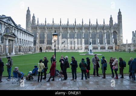 Cambridge, Regno Unito. 24 dicembre, 2013. La gente in coda per il Festival di nove lezioni e canti al King's College di Cambridge Regno Unito, poco dopo l'alba 24 dicembre 2013. Alcuni hanno dormito tutta la notte, sfidando il bagnato e ventoso che ha attraversato il paese per ottenere un buon posto nella coda. Il tradizionale Natale carol concerto ha luogo successivamente alla vigilia di Natale e viene diffuso in tutto il mondo. Credito Eales Julian/Alamy Live News Foto Stock